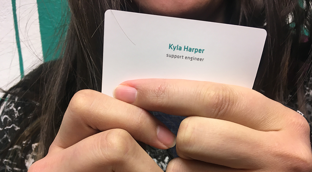 Support engineer Kyla Harper holds up her then-brand-new business card.